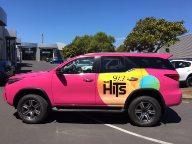 Hot pink vehicle graphics for The Hits.